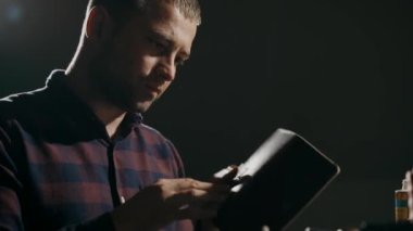 El yapımı deri cüzdan üretme işlemi. Zanaatkar titizlikle bitmiş ürünü inceler. El yapımı deri eşyalar..