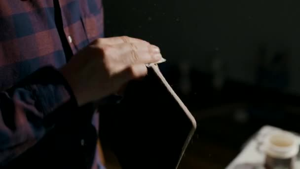 Processen att tillverka en handgjord läderplånbok. Hantverkaren slipar den färdiga produkten. Handgjorda lädervaror. — Stockvideo