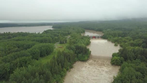 Вид с воздуха на плотину во время наводнений. Чрезвычайно высокий уровень воды в реке. — стоковое видео