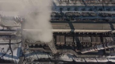 Kömür santralinden gelen gri dumanlı yüksek baca borularının havadan görüntüsü. Fosil yakıtla elektrik üretimi.