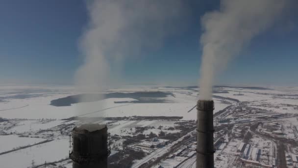 Varmekraftverk - røykende skorsteiner - forskjellige avganger med rød og hvit skorstein om vinteren - frossen dag – stockvideo