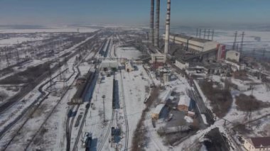 Kömür santralinden gelen gri dumanlı yüksek baca borularının havadan görüntüsü. Fosil yakıtla elektrik üretimi.
