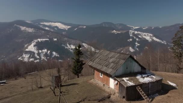 Wiejski dom na tle zimowych gór. Widok z lotu ptaka na piękną panoramę gór. — Wideo stockowe