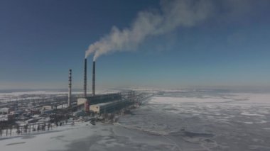Kömür santralinden gelen gri dumanlı yüksek baca borularının havadan görüntüsü. Fosil yakıtla elektrik üretimi.