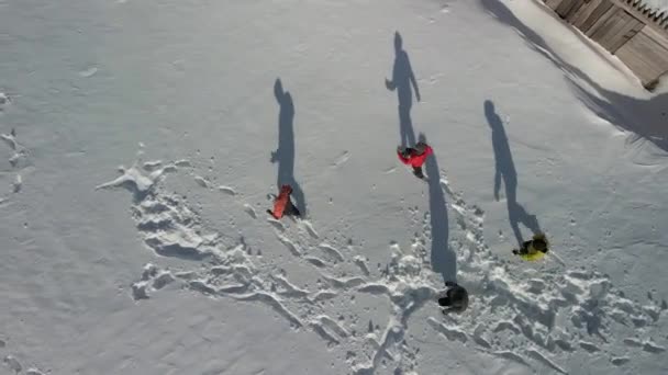 Grandes sombras en la nieve de cuatro viajeros. Vista aérea de personas caminando sobre nieve profunda y dando gran sombra. — Vídeos de Stock