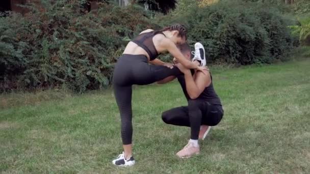 和男教官一起伸展着的女人和男教练一起伸腿的女人 体能训练 妇女伸展训练 个人教官训练伸展练习 女人伸展腿 — 图库视频影像