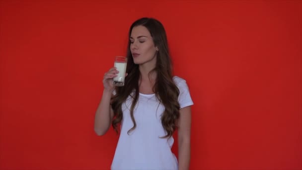 Kobieta Pije Mleko Poranna Dziewczyna Trzyma Szklankę Mlekiem Czerwonym Studio — Wideo stockowe