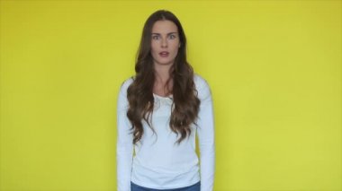 Sarı stüdyodaki korkmuş kadın suratı. Şok olmuş kadın ifadesinin portresi. Şaşırmış kız ifadesi. Sarı arka planda korku insani duygular. Omg yüzlü kadın model.