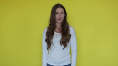 Sarı arka planda şaşırmış kadın yüzü. Şaşırmış kadın yüzü portresi iyi haberlerin tadını çıkarıyor. Ağzı açık, ağzı açık, şaşırmış bir kadın. Güzellik modeli wow ifadesi. Kadınsal duygular