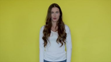 Sarı arka planda şok kadın yüzü. Sürpriz kız duyguları izole edilmiş. Kadın portresi satıştan zevk alıyor. Çekici insan bakışı. Korkmuş kadın, aç ağzını. 