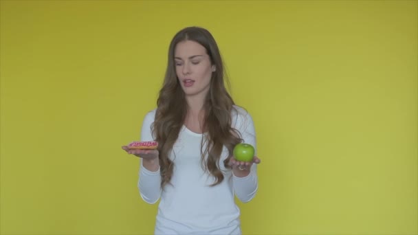 Zdrowe Kontra Niezdrowe Jedzenie Model Brunetka Wybrać Między Jabłkiem Pączkiem — Wideo stockowe