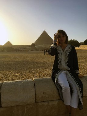 Kahire 'de Mısır piramidi yakınında bir kadın. Giza Piramitleri yakınlarındaki kadın turist. Mısır tatilinde seyahat modeli. Piramitler üzerinde güzel bir model.