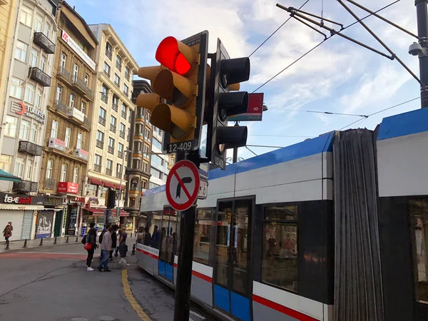 Tramvay yolunda trafik ışığı kırmızı yanıyor. Tramvayın yanında kırmızı ışığı olan modern bir şehir. Tramvaylı Türk sokağı. Travel taşıma caddesi. Yaya geçidi taşımacılığı caddesi 
