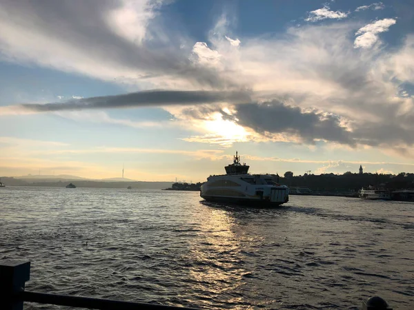 Günbatımında Bosphorus Nehri 'nde bir turist teknesi. Boğaz şehrinde güzel bir turizm gemisi. Türkiye 'de deniz gezisi. Mavi tekne Türk denizinde seyahat ediyor