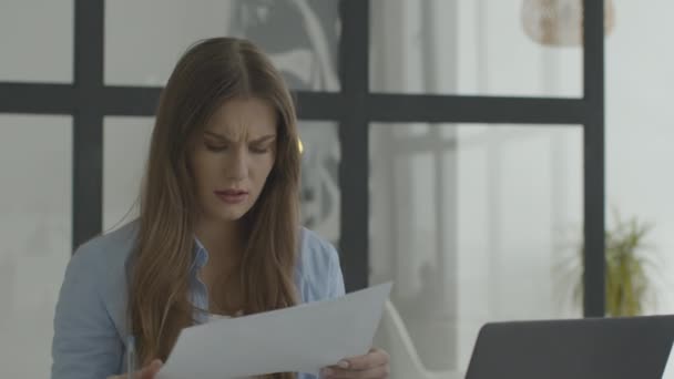 Serious mulher rosto procurando documentos no local de trabalho home laptop — Vídeo de Stock