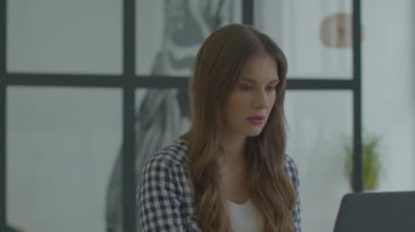 Kadın merkez ofiste dizüstü bilgisayarla çalışıyor. Bilgisayar kullanan çekici kişi