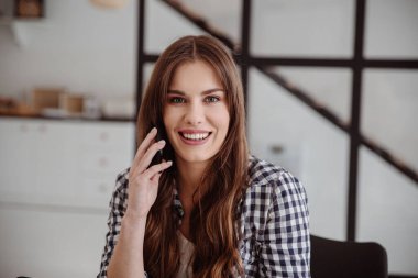 Beyaz stüdyoda konuşan bir iş kadını. İş konuşmalarının portresi