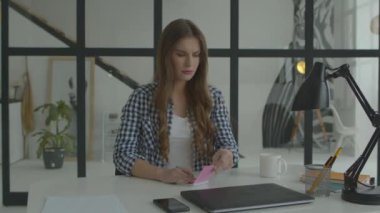 Laptop işyerinde not alan bir kadın. Bilgisayarda not yazmakla meşgul bir kadın.