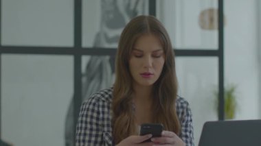 Laptop masasında cep telefonu kullanan bir iş kadını. Telefon kullanan bir iş adamı.