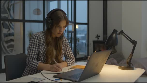 Online learning woman making notes at desk. Remote learning lessons from home — стоковое видео