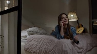 Geceleri yatakta telefonla konuşan bir kadın.. 