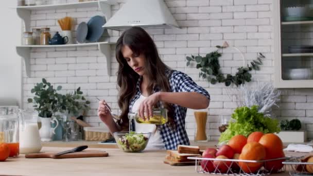 Mulher derramando óleo em salada de legumes. Mulher vestir salada fresca com azeite — Vídeo de Stock