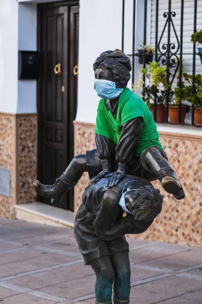 Sokakta oynayan iki çocuğun bronz heykelleri. Yüz maskeleri takarak birbirlerinin üstüne atlıyorlar.