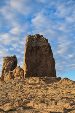 Roque Nublo, gün batımında hafif bulutlu mavi gökyüzü ile fotoğraflandı..