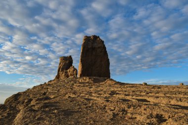 Roque Nublo, gün batımında hafif bulutlu mavi gökyüzü ile fotoğraflandı..
