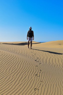 Yalnız gezgin sırt çantasıyla çöl kum tepelerinde yürüyor..