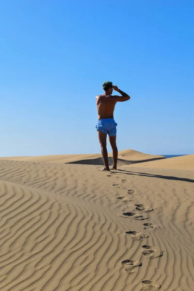 穿着泳裤在沙漠沙丘中行走的人 — 图库照片