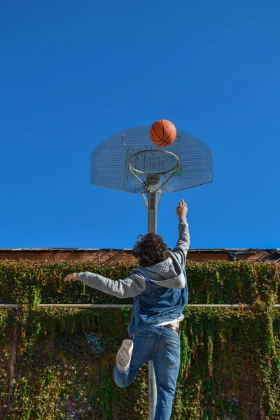 Νεαρός Που Παίζει Μπάσκετ Πηδώντας Προς Καλάθι Εικόνα Αρχείου