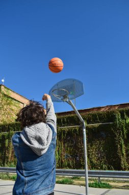 Basketbol kalesine top atan bir adam.