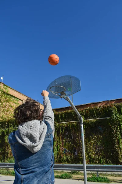 Man throwing a ball into the basketball net.