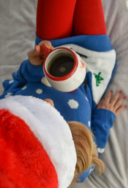 Kobieta Siedząca Łóżku Świątecznych Ciuchach Pijąca Kawę — Zdjęcie stockowe