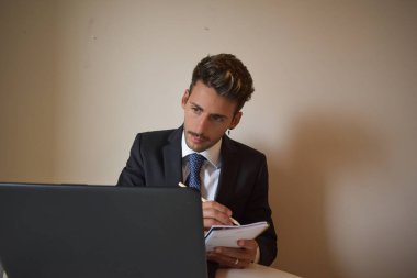 Bilgisayarda çalışan takım elbiseli iş adamı.