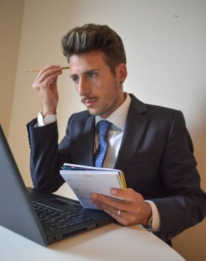 Bilgisayarda çalışan takım elbiseli iş adamı.