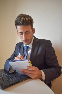 Bilgisayarda çalışan takım elbiseli iş adamı.