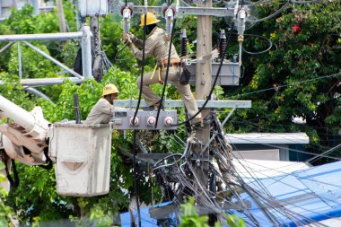 Elektrik işçileri yüksek voltajlı elektrik hattının onarımına ve bakımına yardım ediyorlar. Nonthaburi Eyaleti, Tayland, Tarih 06-08-2020