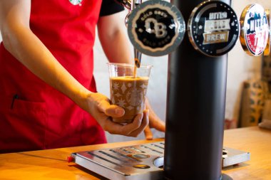 Starbucks kahve dükkanı çalışanları, 13-11-2020 'deki bir Tayland dükkanındaki müşterilere bir fincana nitro kahve dolduruyor..