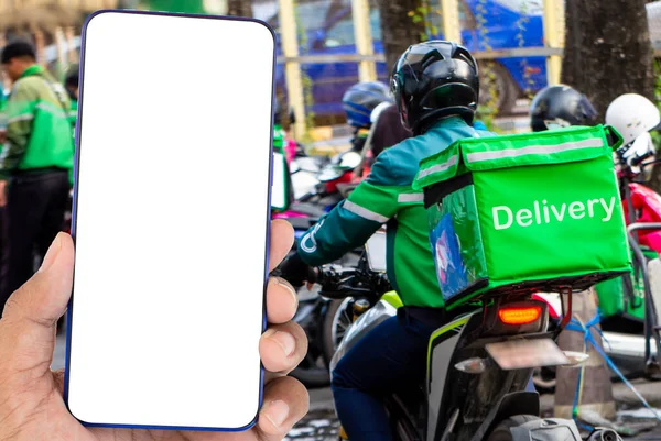 Mesajları ve kırpma yolları olan tasarımları yazmak için boş ekranı olan bir akıllı telefon. Yemek dağıtım şoförü, üniformalı, yeşil, arkasında yemek torbası olan internetten yemek siparişi veren.