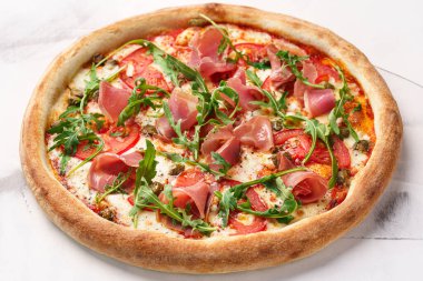 Prosciutto, domates, peynir, roka, kapari ve domatesli İtalyan pizzası.