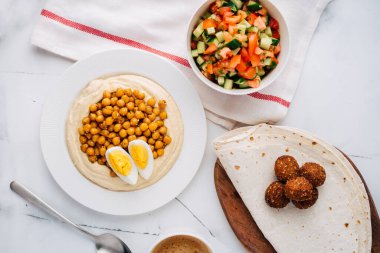 Haşlanmış nohut, yumurta, falafel, lavaş ve salata ile humus. Düz Yat. Üst görünüm