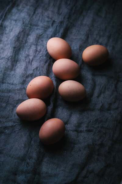 Eggs on dark fabric background. Easter, spring or eco food concept.