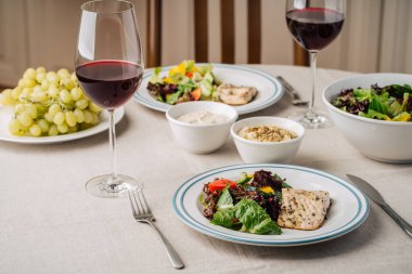 Sebze salatalı beyaz balık bifteği, sos, humus, üzüm ve bir bardak şarap. Mutfakta iki kişilik servis yaptım.