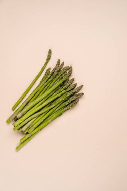 Bej arka planda taze organik kuşkonmaz filizleri ve tasarımın için fotokopi alanı. Sağlıklı gıda konsepti.