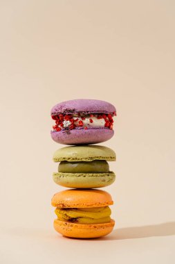 Renkli badem kurabiyesi kulesi ya da bej arka planda badem kurabiyesi