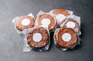Elektrik süpürgesinde çiğ vejetaryen pirzola, arka planda hamburger. Model etiketi