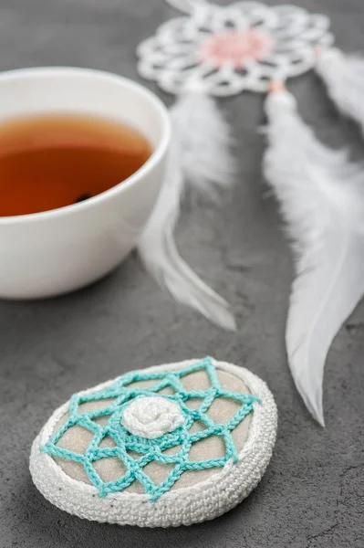 Cup of tea and crocheted pebble — Stock Photo, Image