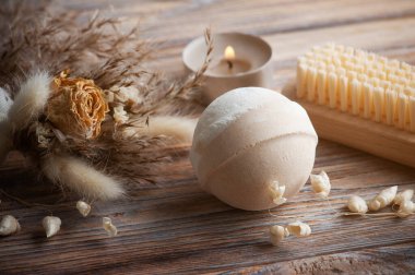 Vanilyalı şeftali aromalı banyo bombaları ve kuru çiçekler. Aromaterapi düzenlemesi, yanan mumlar ve vücut fırçalarıyla dolu bir hayat.